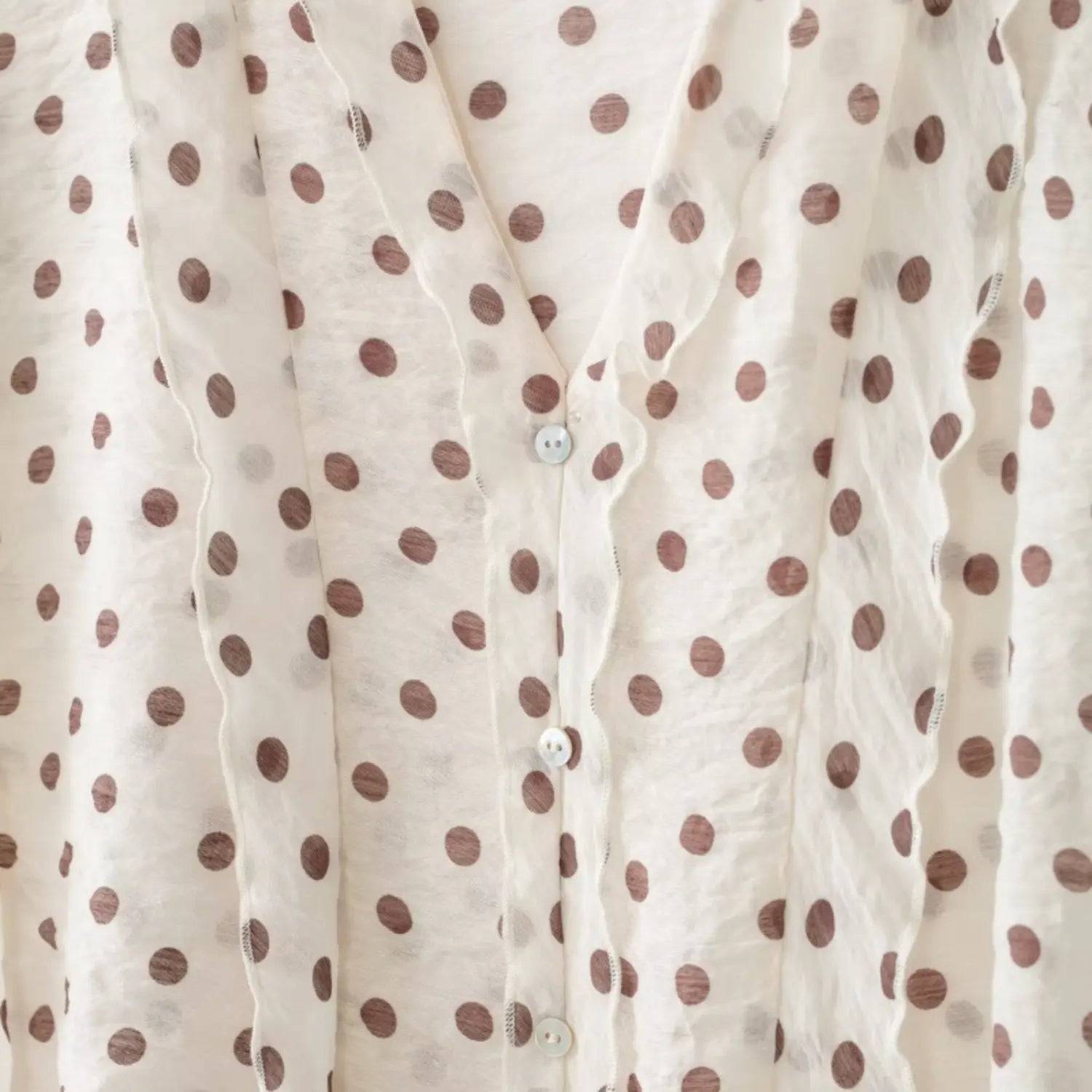 Macro close-up of natural round shell buttons set within wavy ruffle placket
