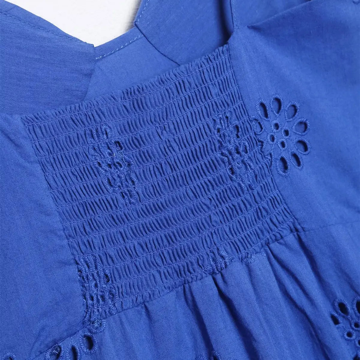 Back detail of royal blue eyelet ruffle dress, showing the smocked elastic panel for a flexible fit and eyelet embroidery