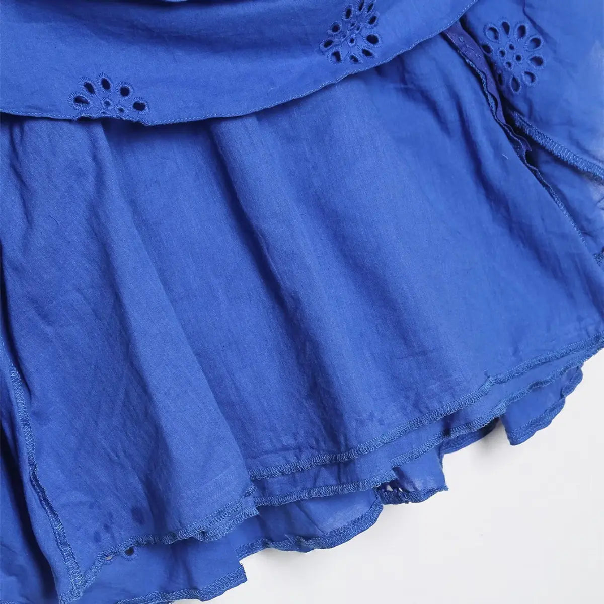 Hem detail of royal blue eyelet ruffle dress, showing the tiered layers, eyelet embroidery, and stitched edge finish