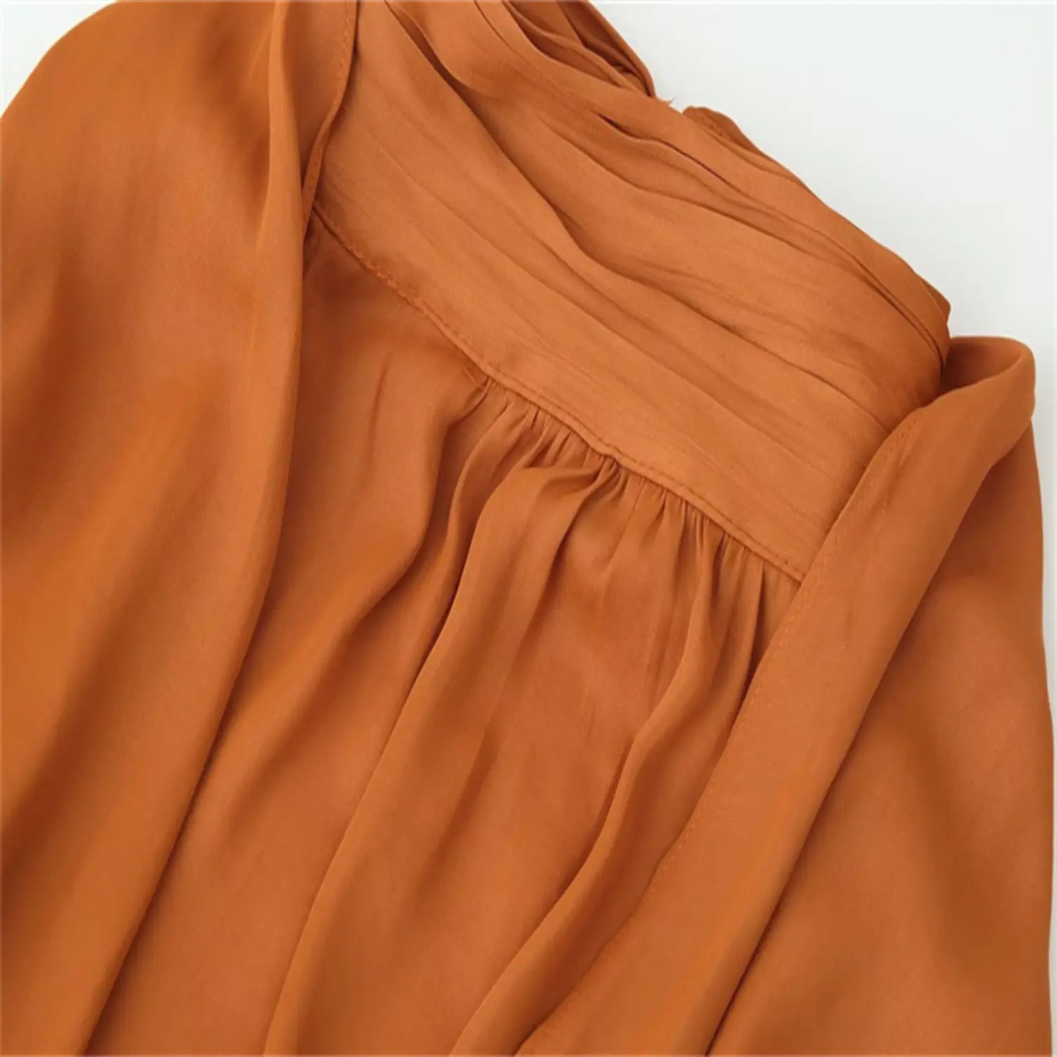 Close-up of multi-layer ruched high neck, elastic gathering under collar, lightweight glossy satin fabric