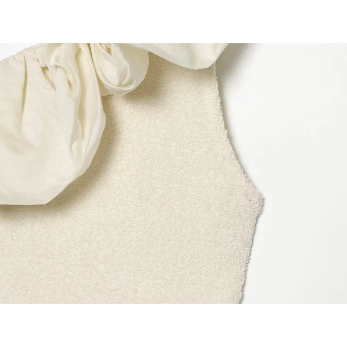 Side seam close where satin ruffle connects with terry knit bodice