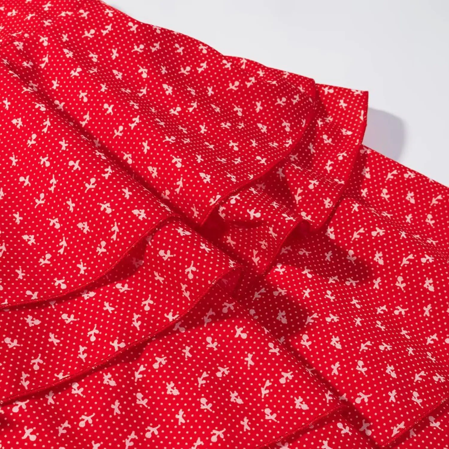 Macro detail of layered ruffle fabric on red ditsy floral mini skirt