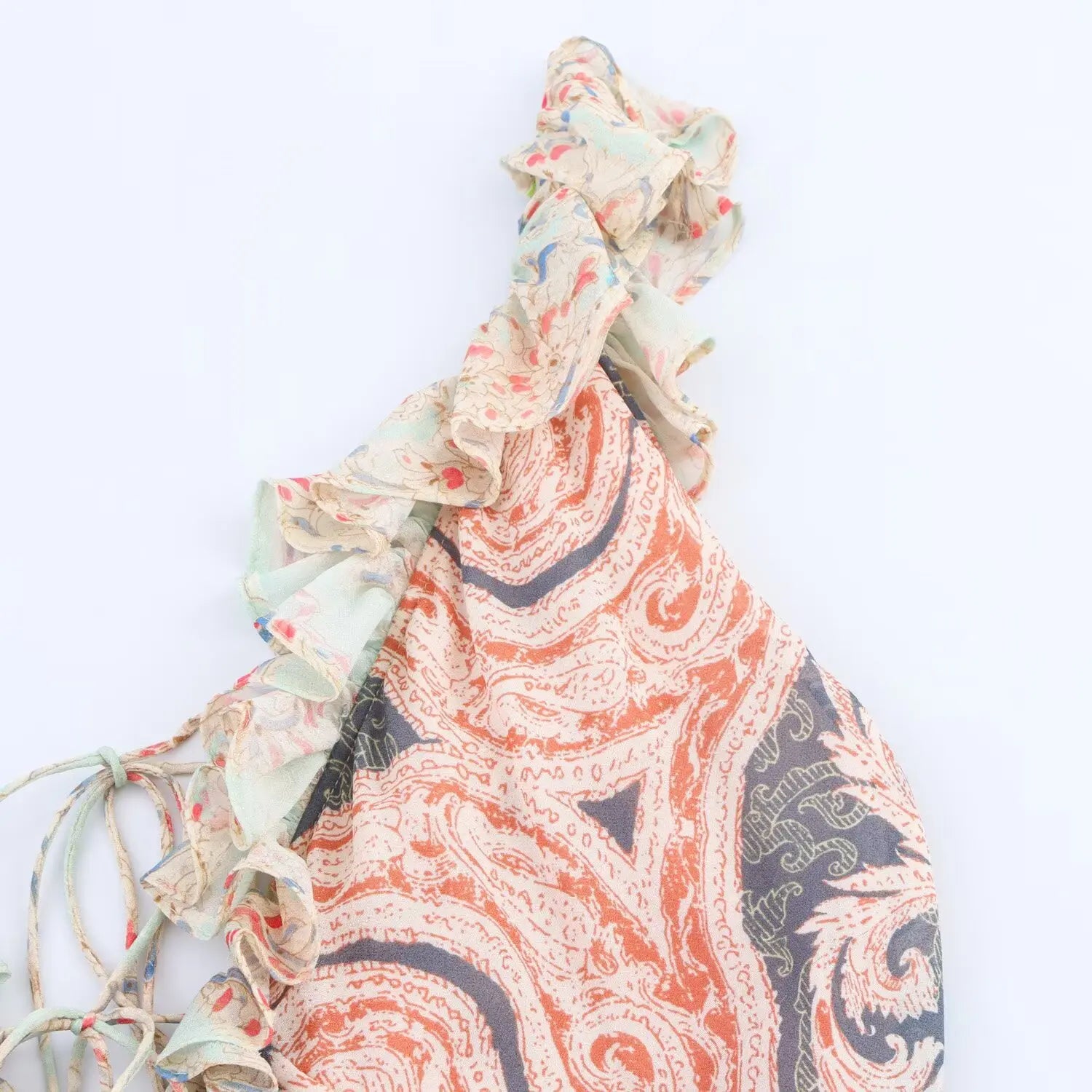 Partial close‑up of ruffle cami strap, layered frill chiffon fabric, mixed‑color paisley pattern