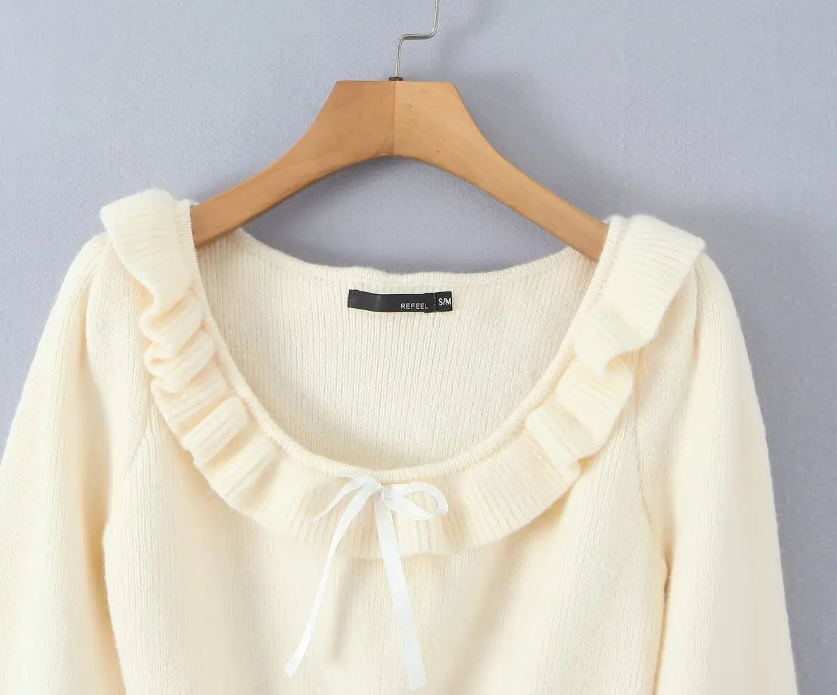 Close-up of ruffle scoop neck and satin ribbon bow
