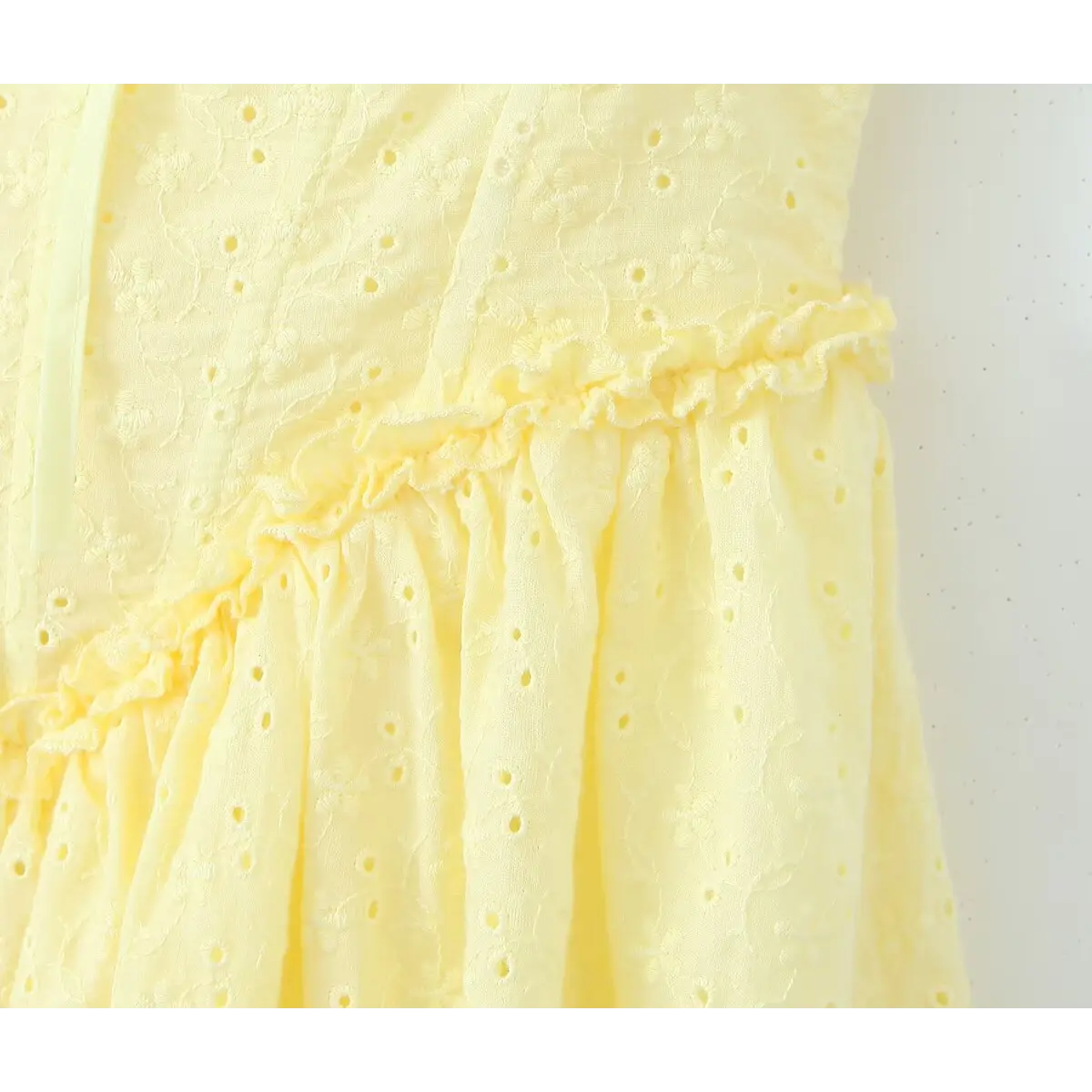 Waist close view, frill ruffle trim at skirt joint, gathered flare skirt on yellow embroidered fabric.
