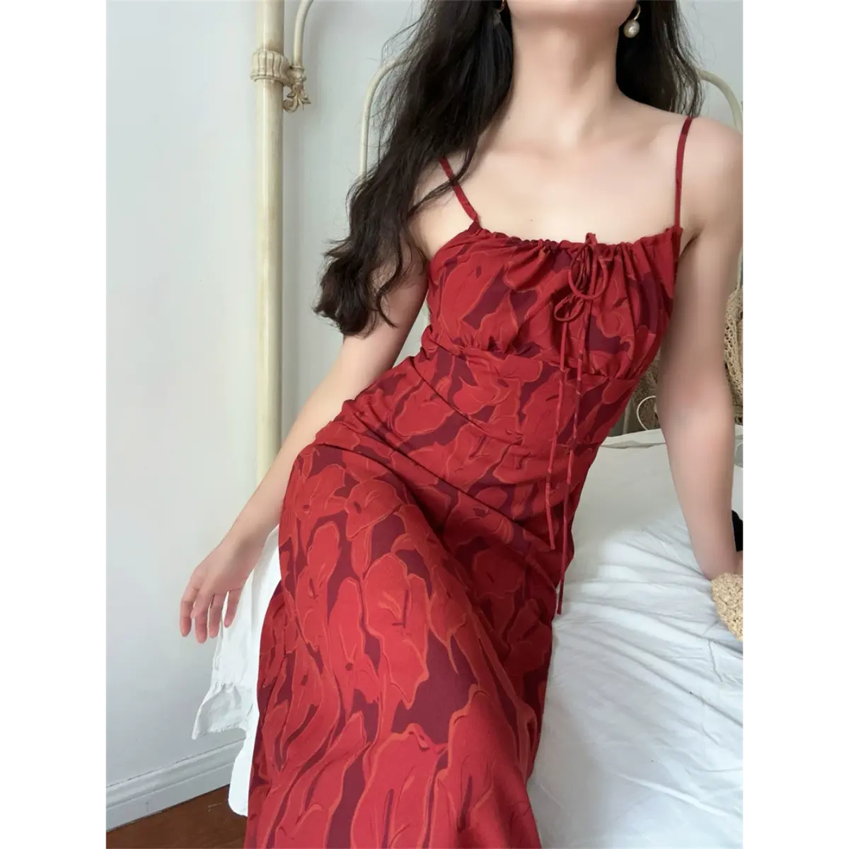 Close indoor lifestyle shot of vintage terracotta abstract floral spaghetti strap midi dress, front drawstring ruched bust and slim fitted skirt.