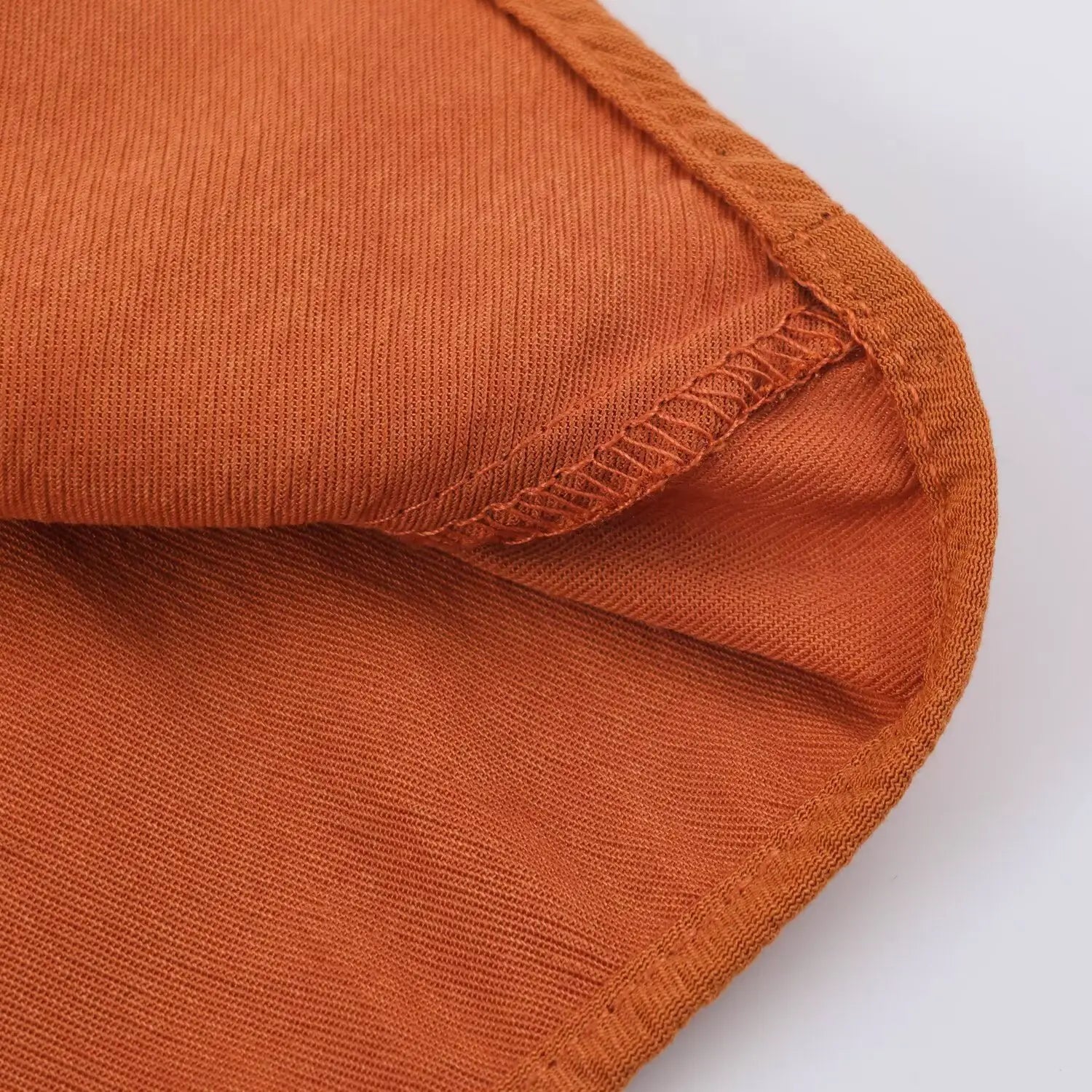 Macro shot showing fabric thickness, inner weave texture of rust textured romper material
