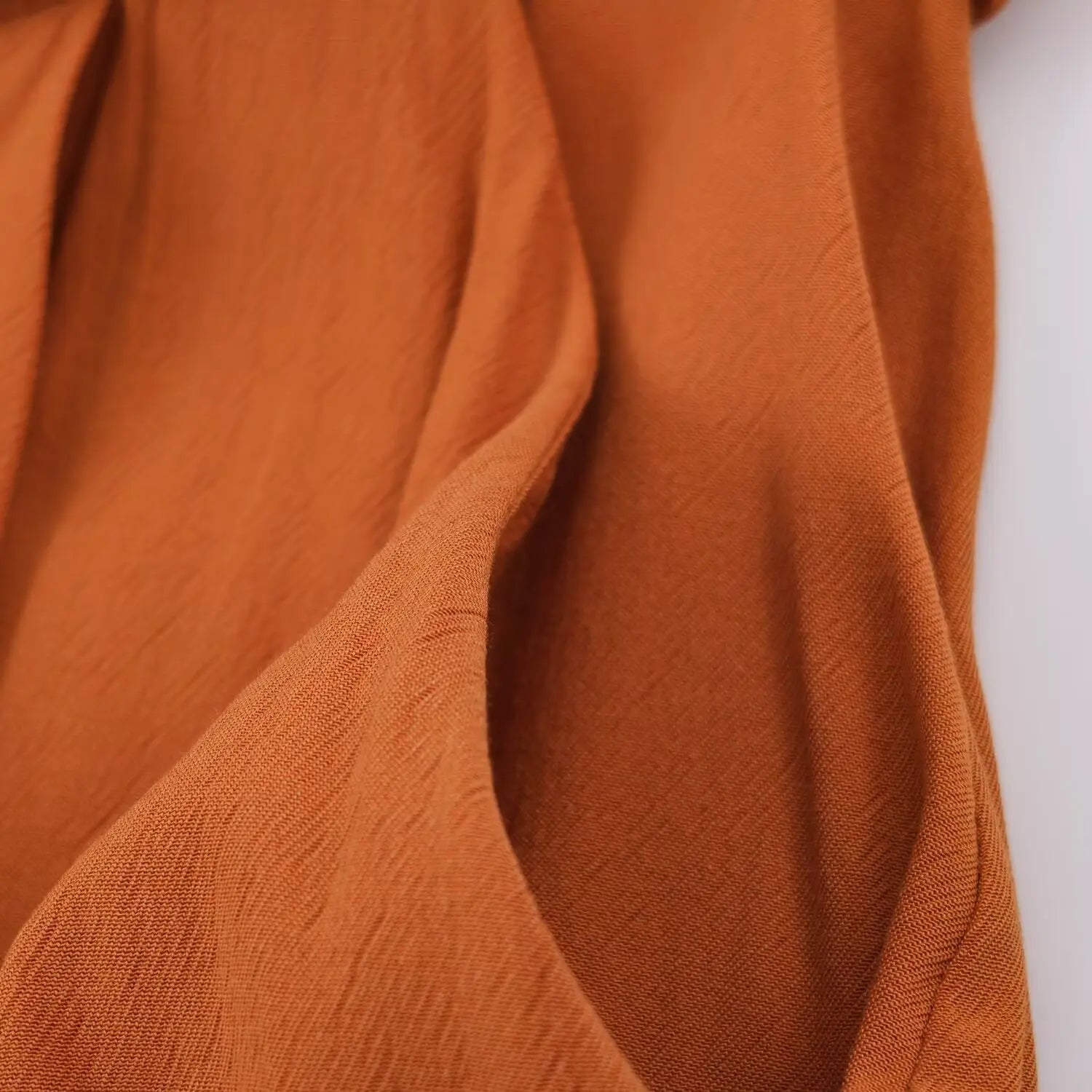 Side inseam pocket partial shot, hidden pocket design on rust brown sleeveless playsuit