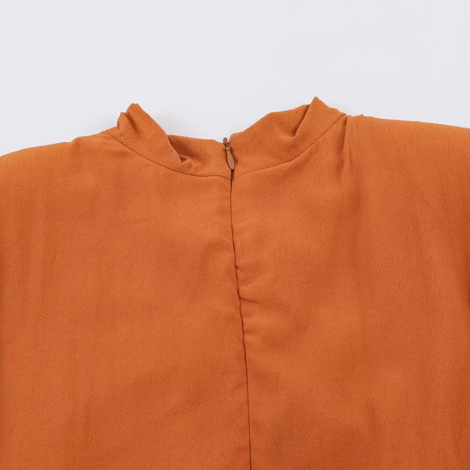 Back cowl neck overview of rust romper, center invisible zipper stand collar detail