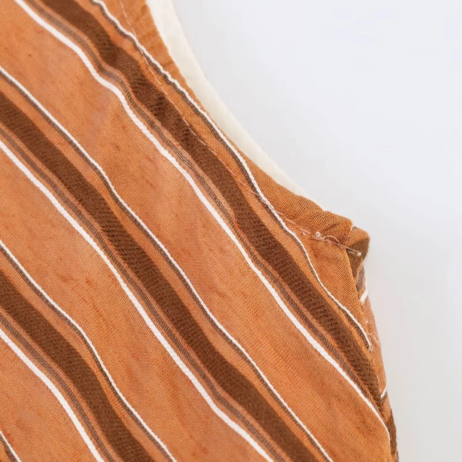 Close-up fabric texture of rust chevron stripe maxi dress, lightweight woven material