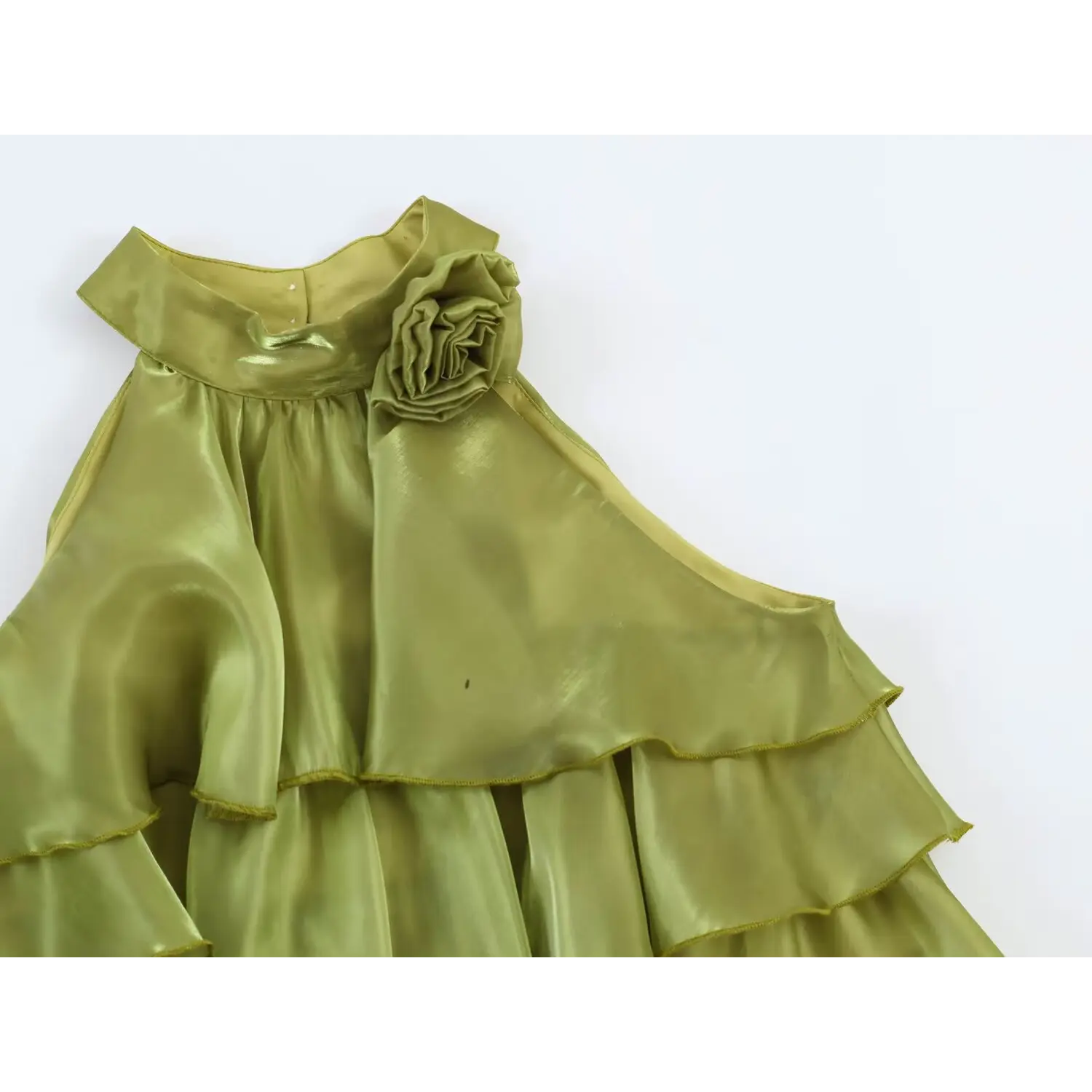 Macro shot 3D rolled fabric rose decoration at halter neck, glossy sage green organza textile