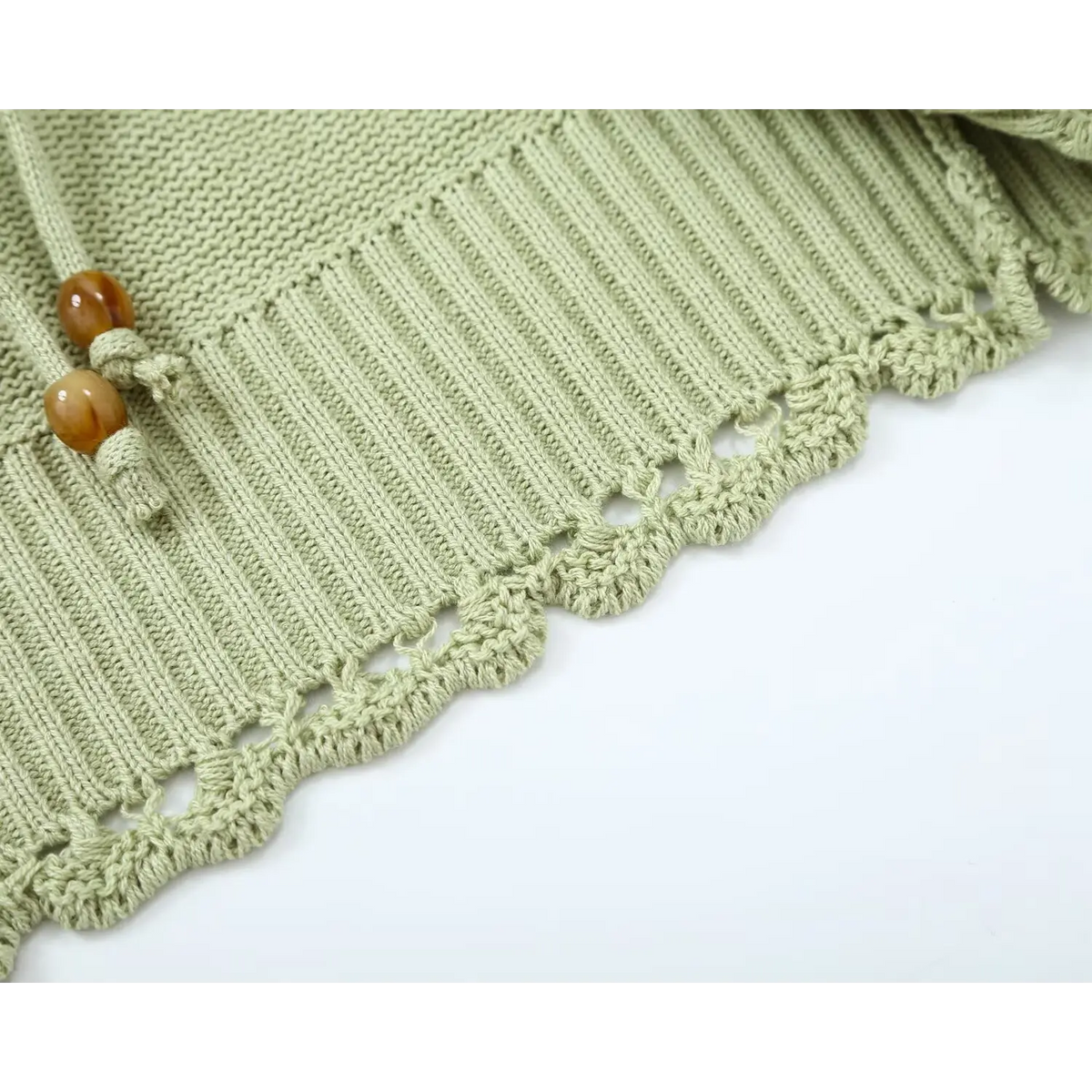 Close-up of scalloped hem edge and amber bead tassel