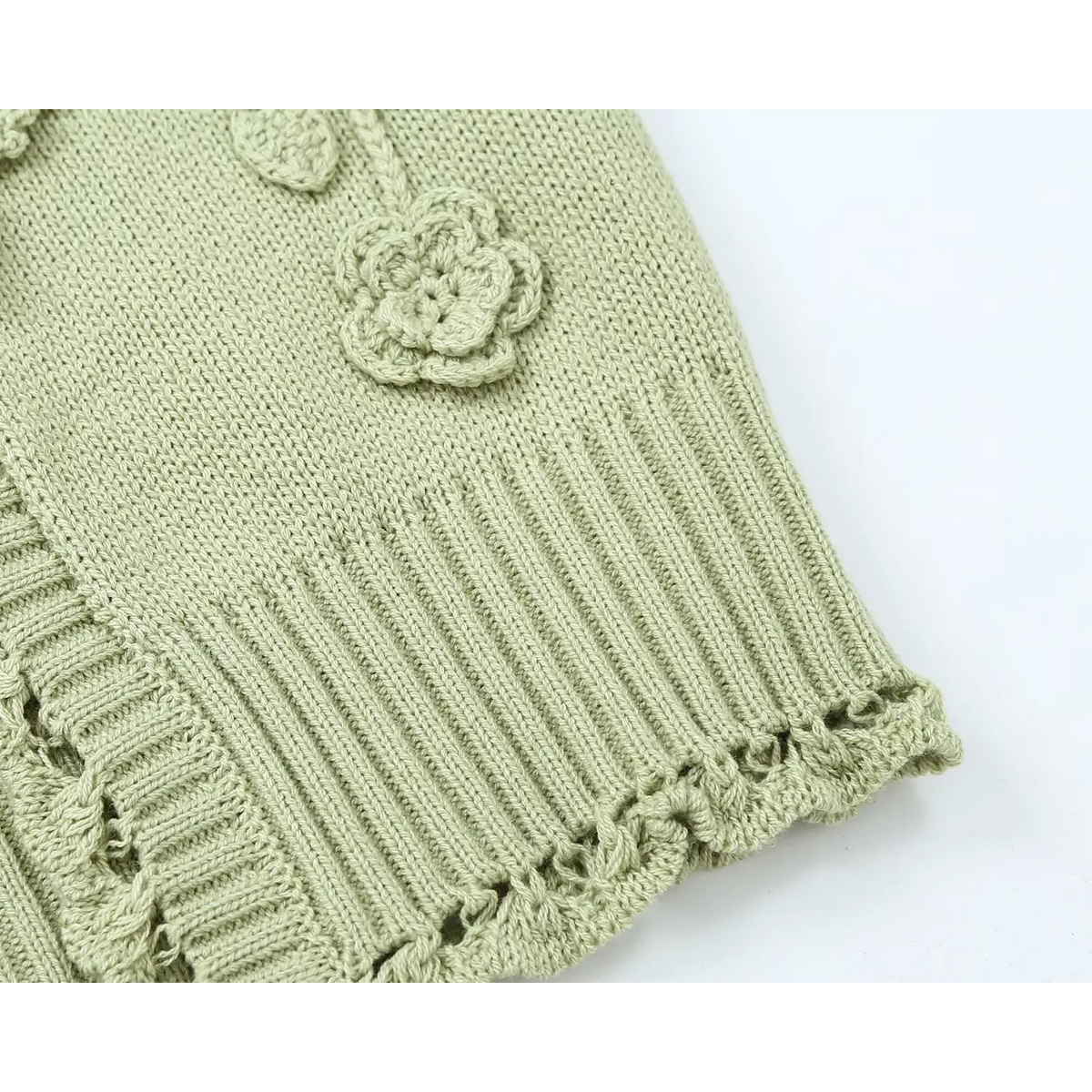 Close-up of ribbed hem and crochet flower applique detail