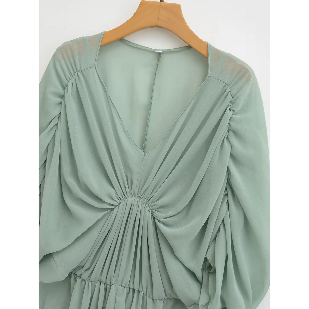 Close-up of outer dress V neck and gathered bust pleats