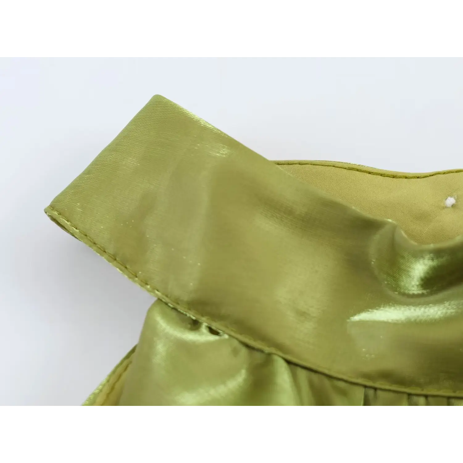 Closeup halter stand collar folded edge, neat stitching, shiny sage green organza fabric texture