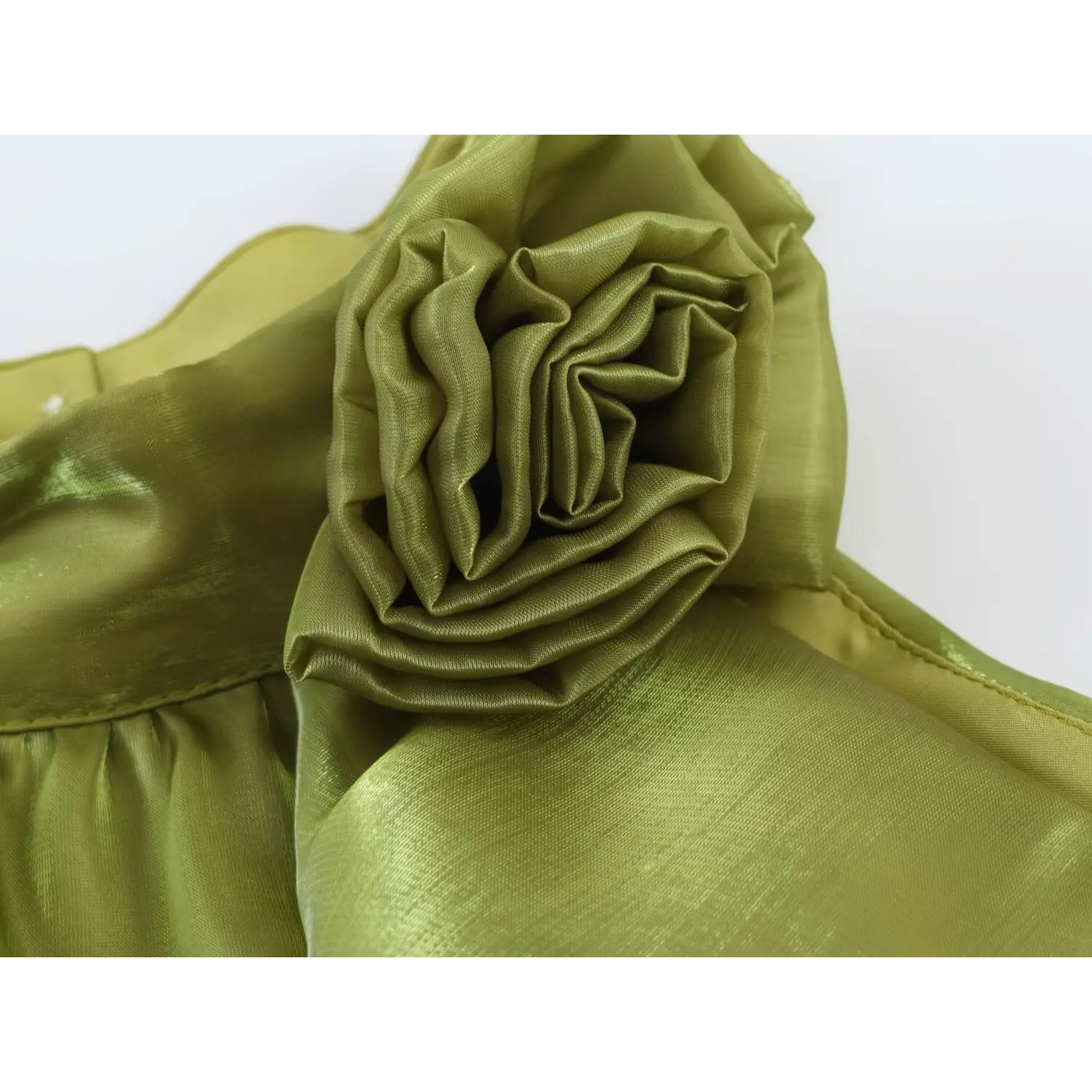 Extreme closeup layered rolled fabric rose ornament, solid sage green woven material