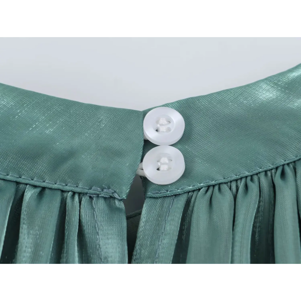 Close-up of white buttons at back neck