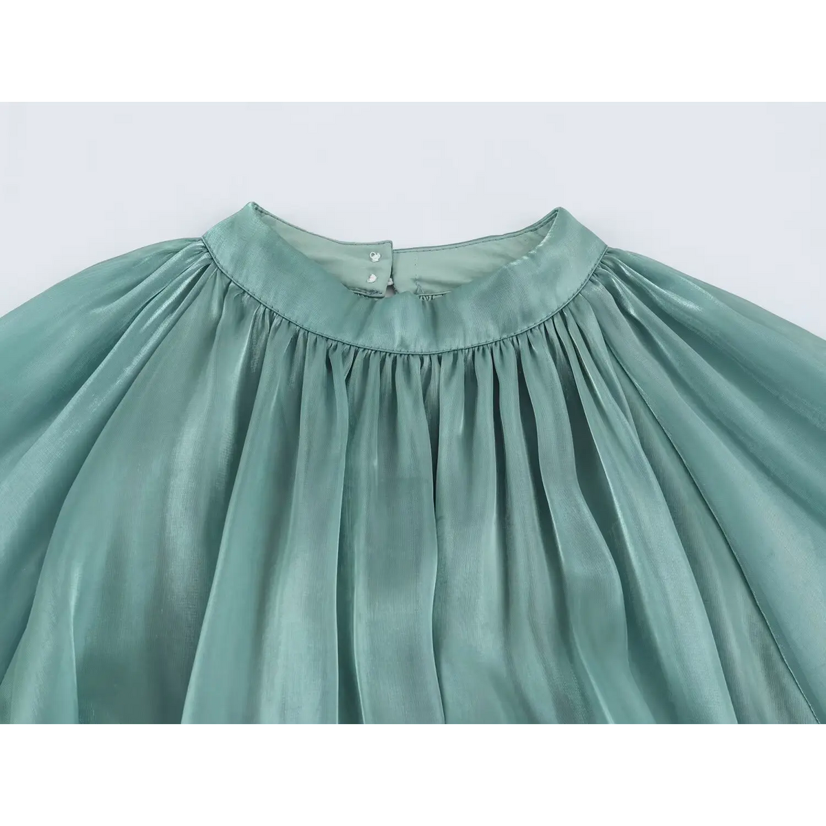 Close-up of gathered high neck, buttons and pleats