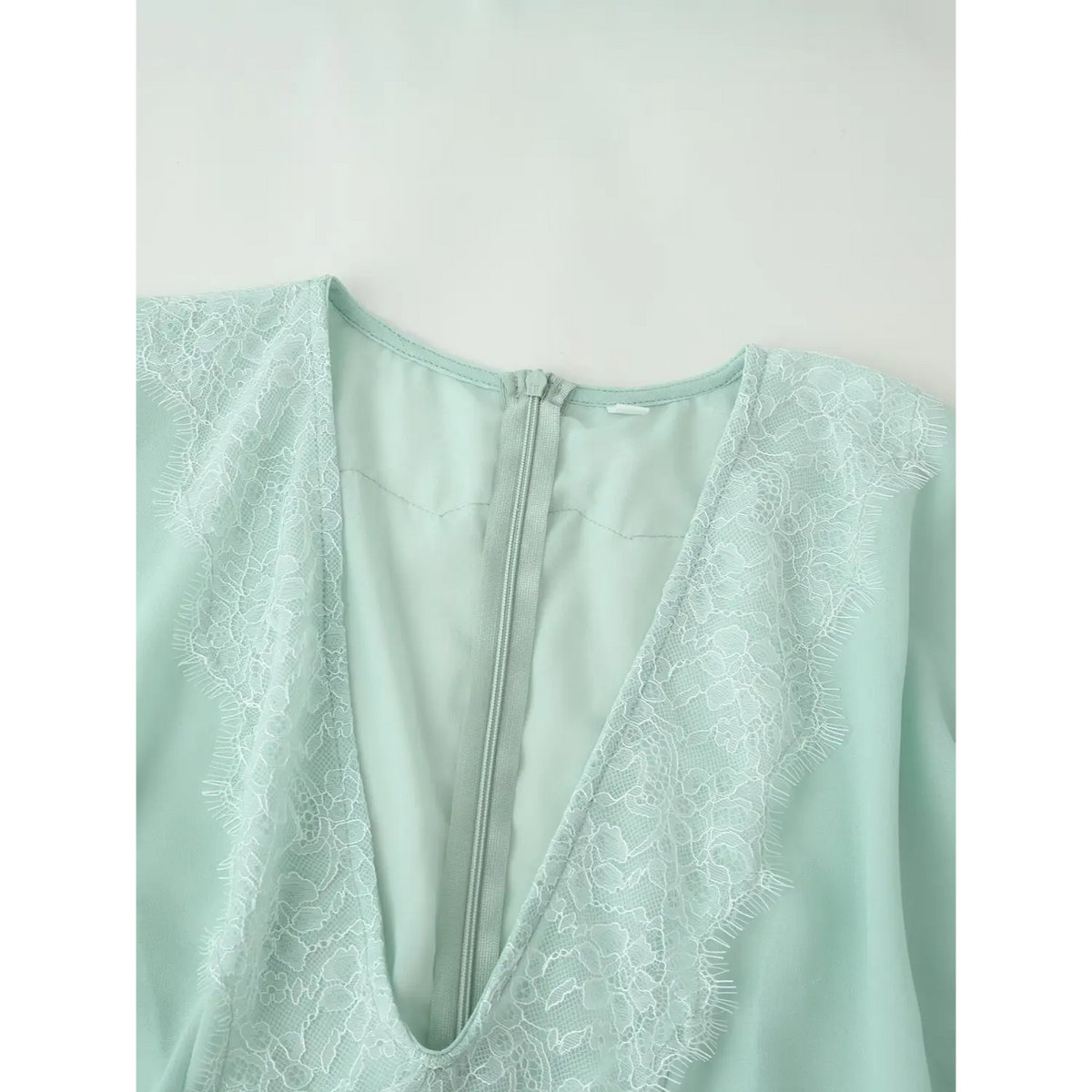 Close-up of V-neck lace trim and back zipper