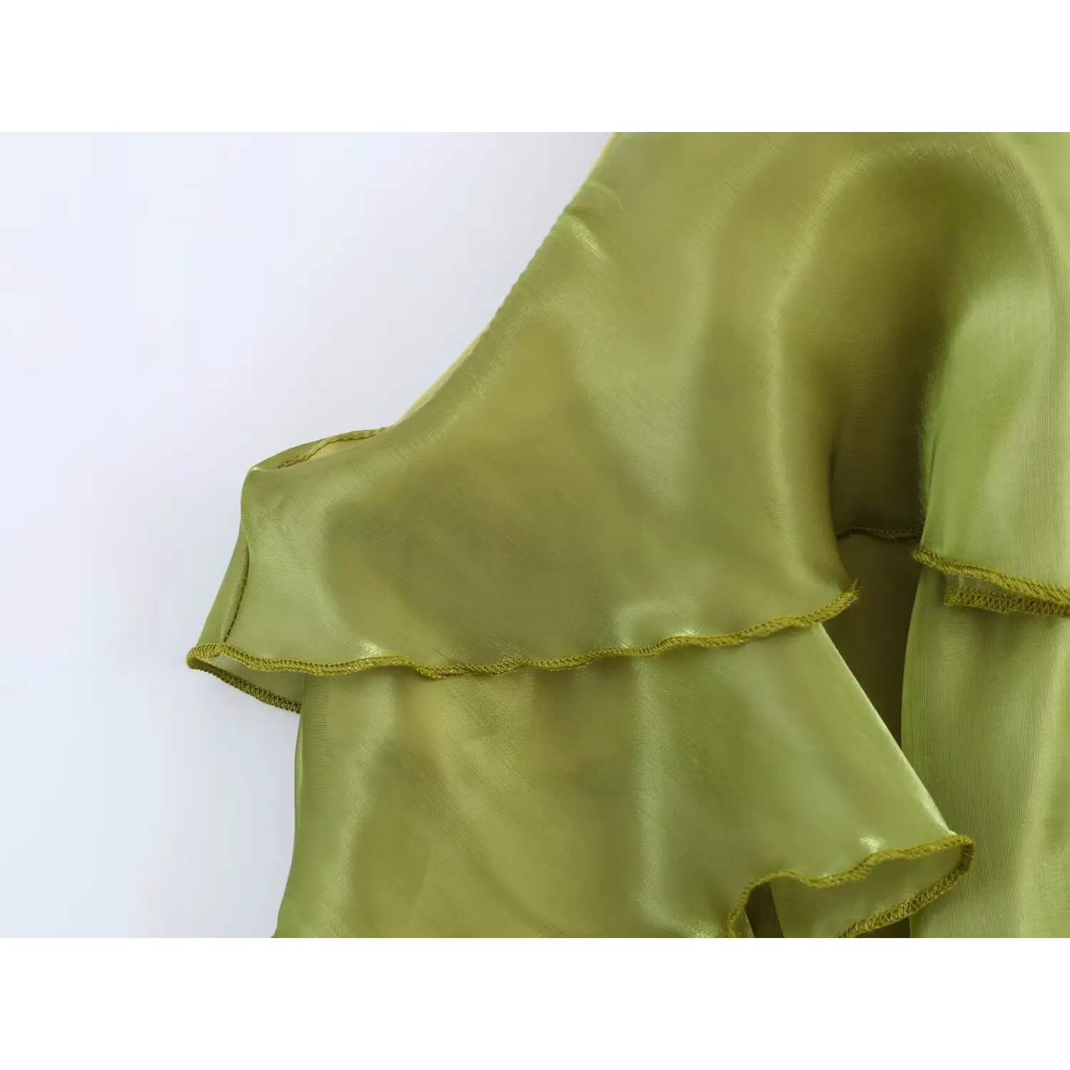 Closeup scalloped finished edge of ruffle tier hem, lightweight shimmer sheer fabric texture