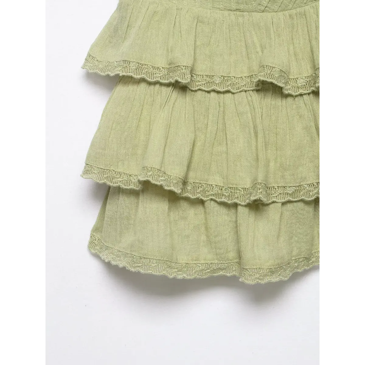 Close-up of the cami top's ruffled hem, showing the layered tiers and lace trim.