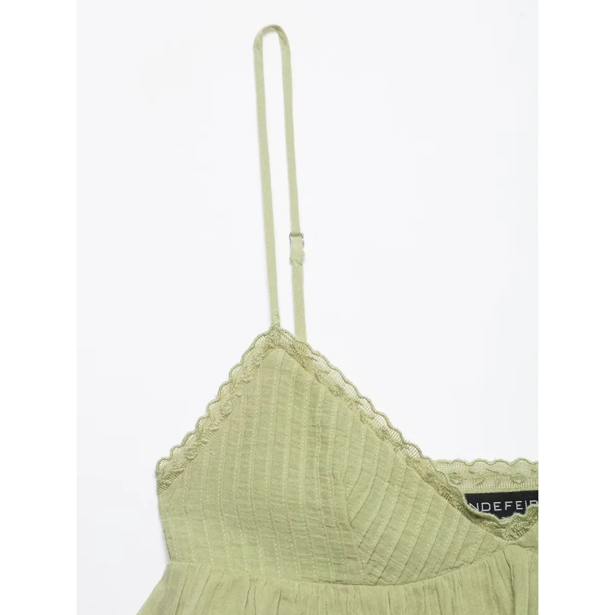 Close-up of the cami top's adjustable spaghetti strap and V-neckline.