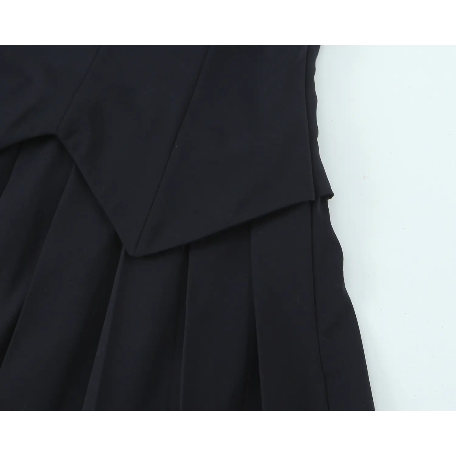 Macro waist junction shot, pointed overlapping front panel dividing bodice and pleated skirt, vertical shaping darts on torso
