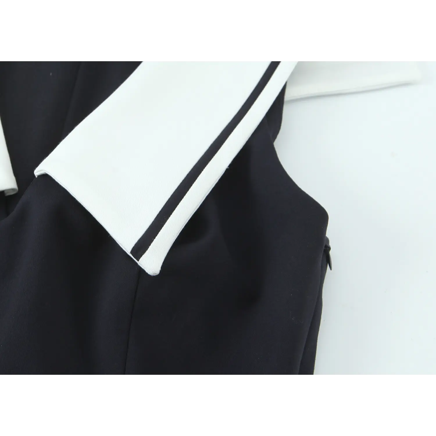 Shoulder partial shot, white lapel thin black piping binding, sleeveless armhole, matching invisible side zipper for easy wear
