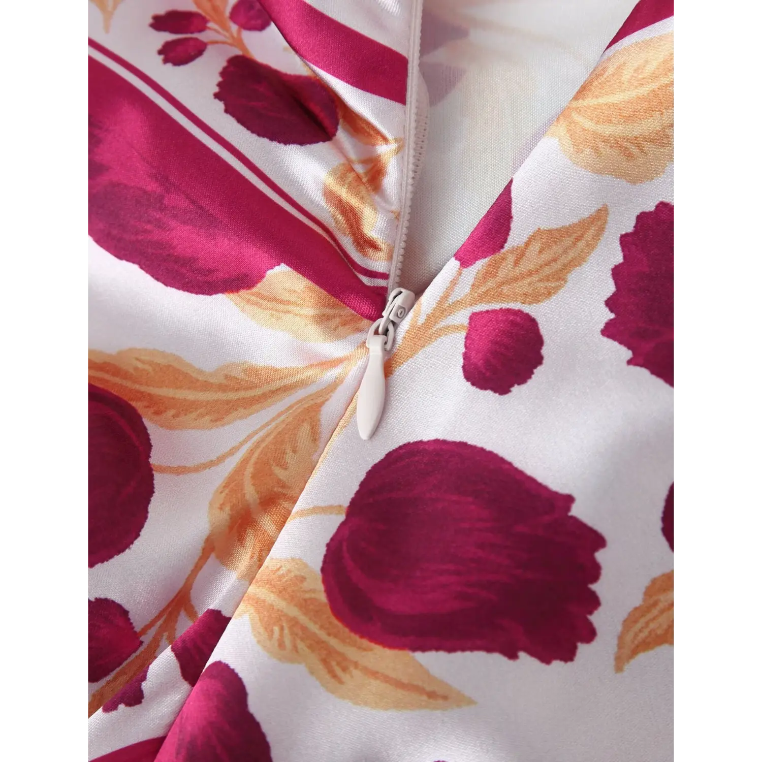 Macro close‑up of invisible side zipper on burgundy floral satin maxi dress, fabric print and zipper hardware detail