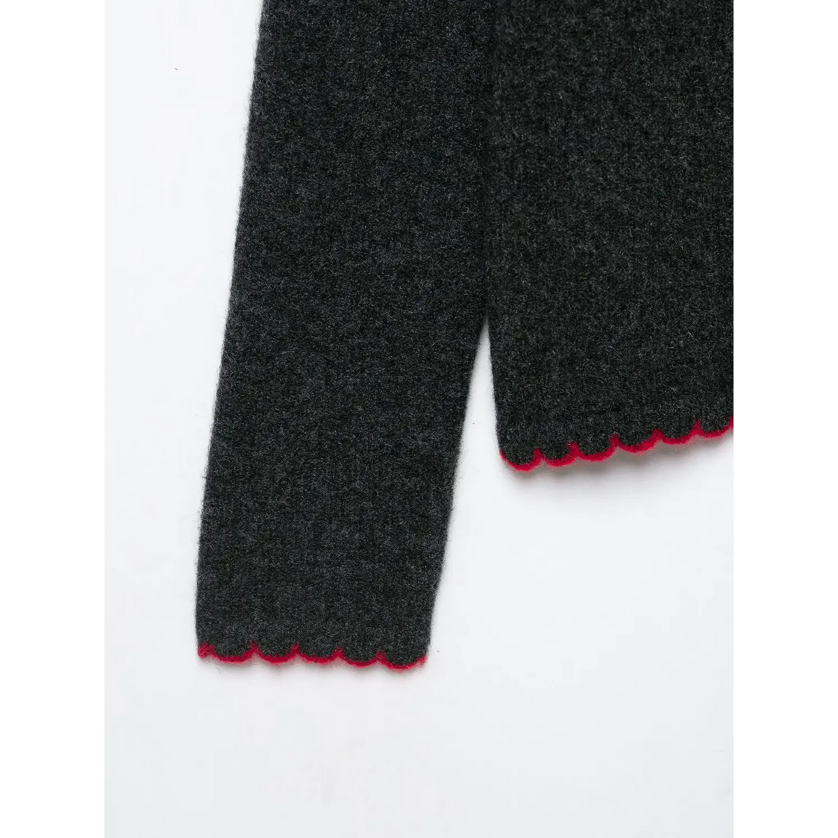 Close-up of red scalloped cuff and hem on dark gray cardigan