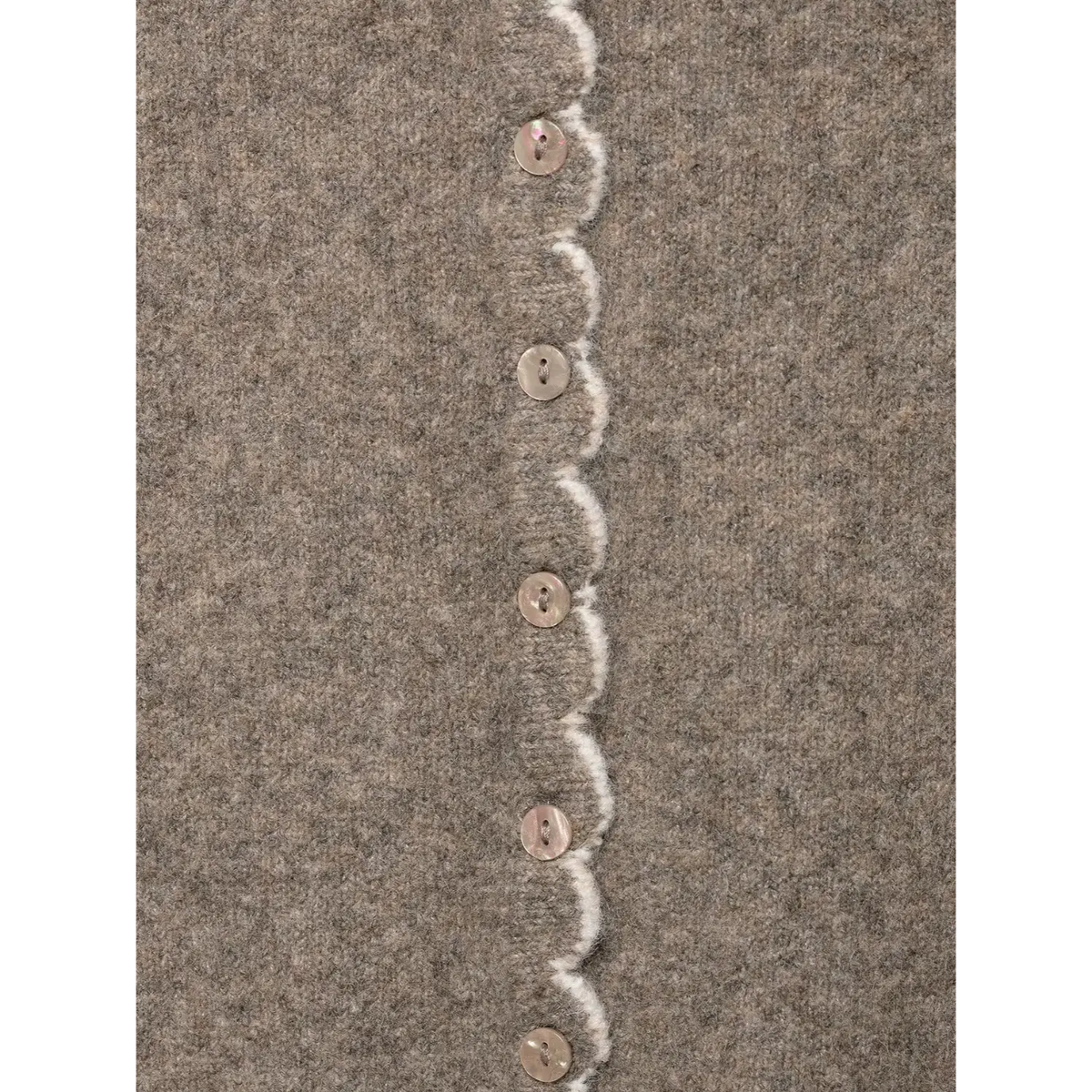 Close-up of vertical button row with white scalloped placket
