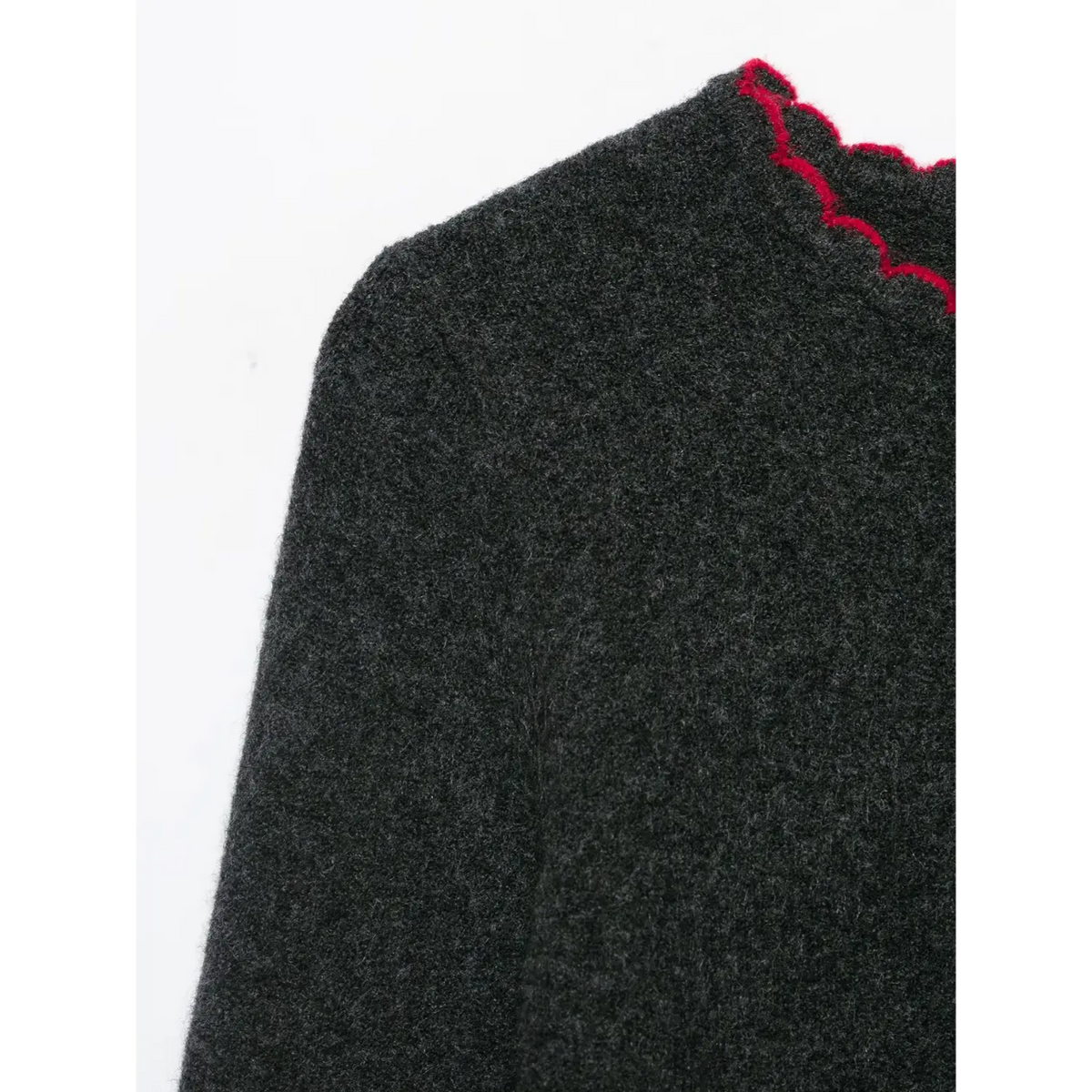 Close-up of dark gray shoulder and red scalloped neckline