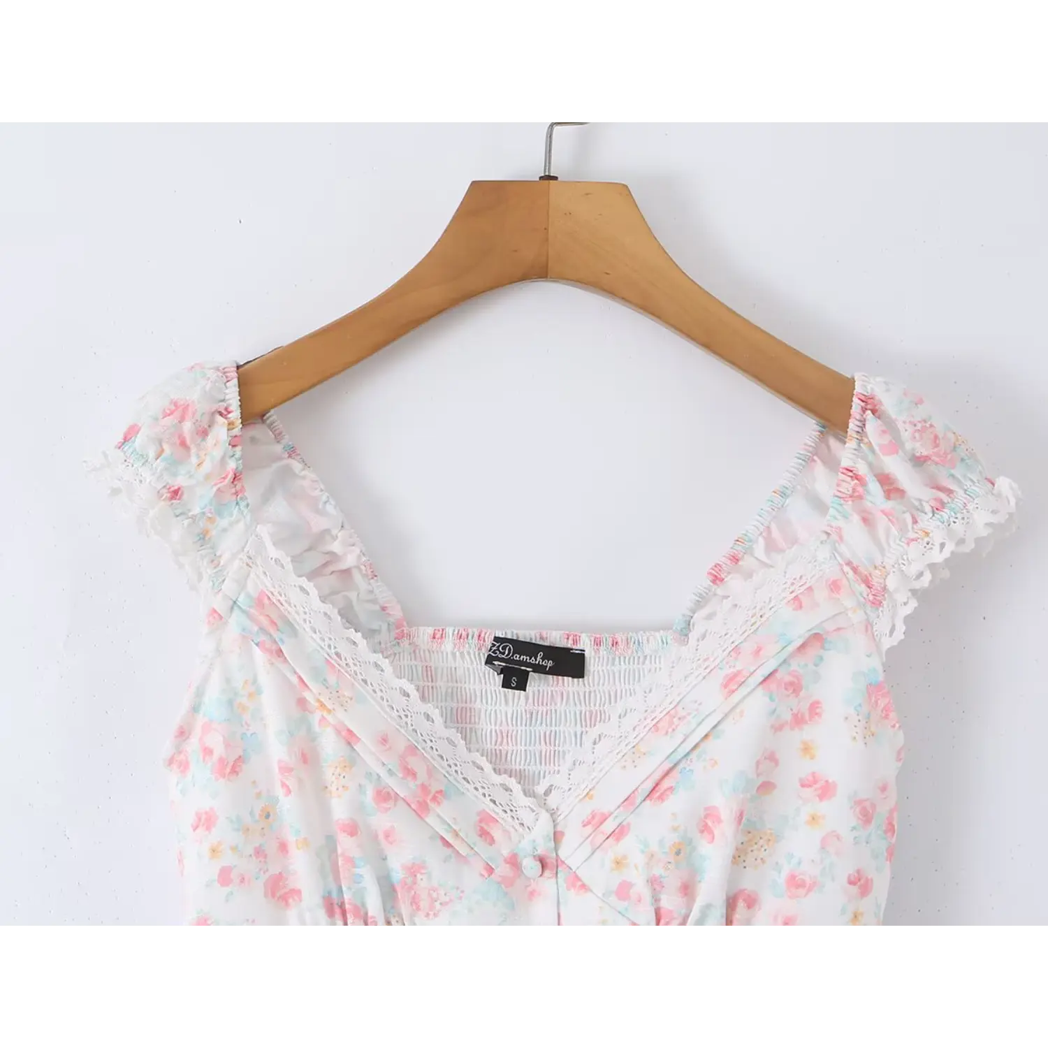 Wood hanger bust full partial shot cropped cami, elastic gathered ruffle cap sleeves with eyelet lace trim, wrap deep V neck lined with scalloped hollow lace, vertical self-fabric button placket, pastel watercolor mixed floral print