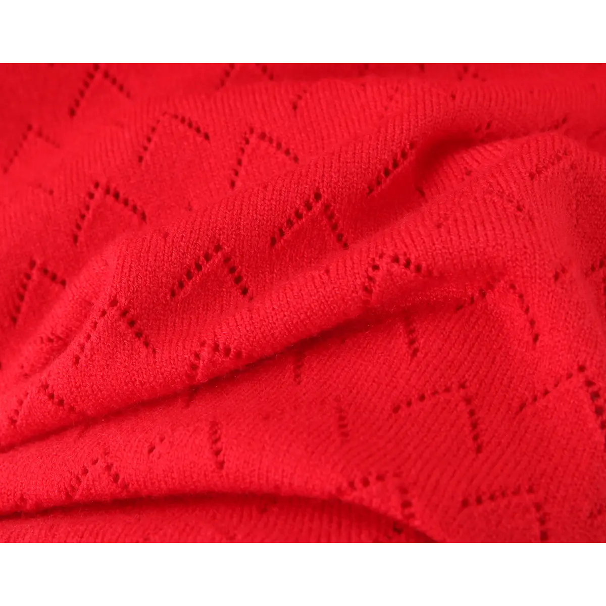 Folded fabric close of red chevron hollow knit, soft stretch knit texture for bodycon dress.