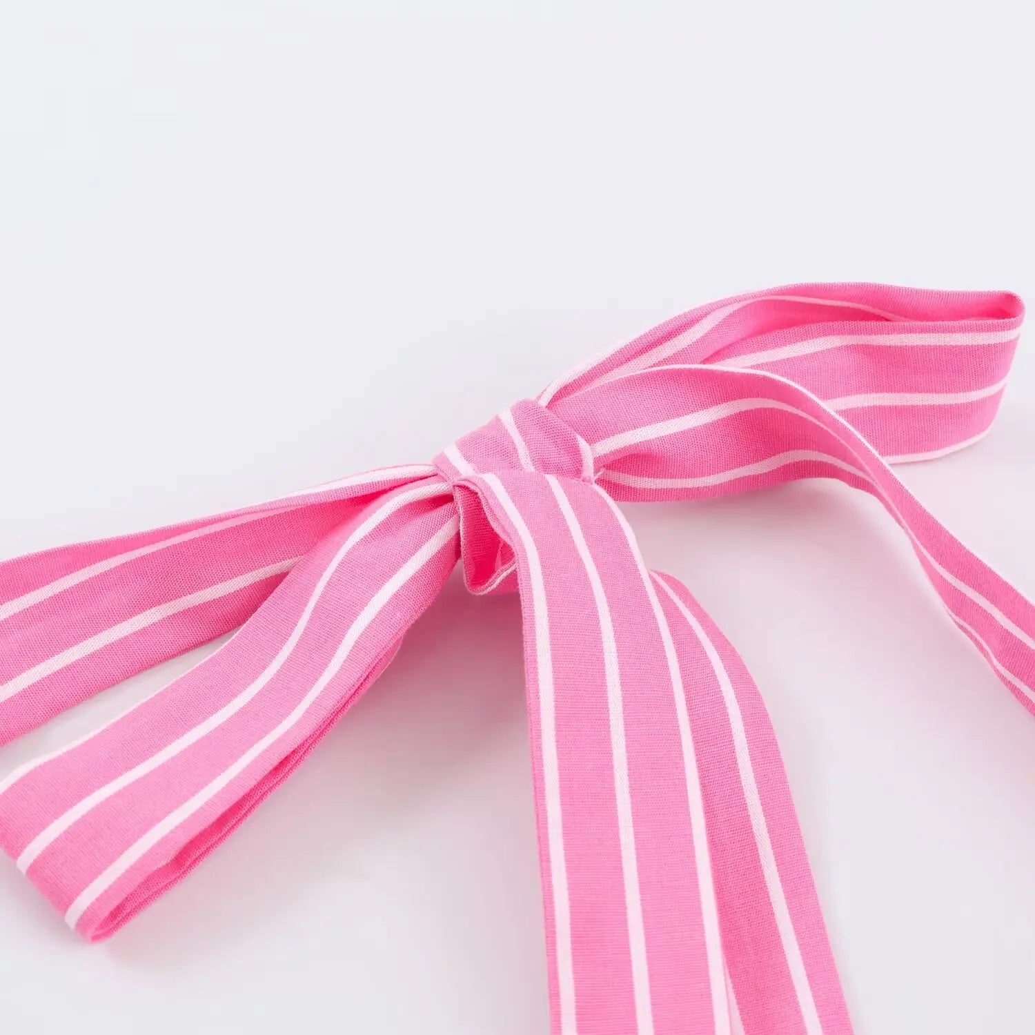 Extreme closeup matching pink white stripe fabric tie knot for spaghetti strap