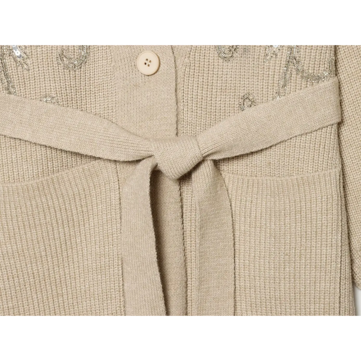 Close-up of matching knit belt tied in knot above patch pockets