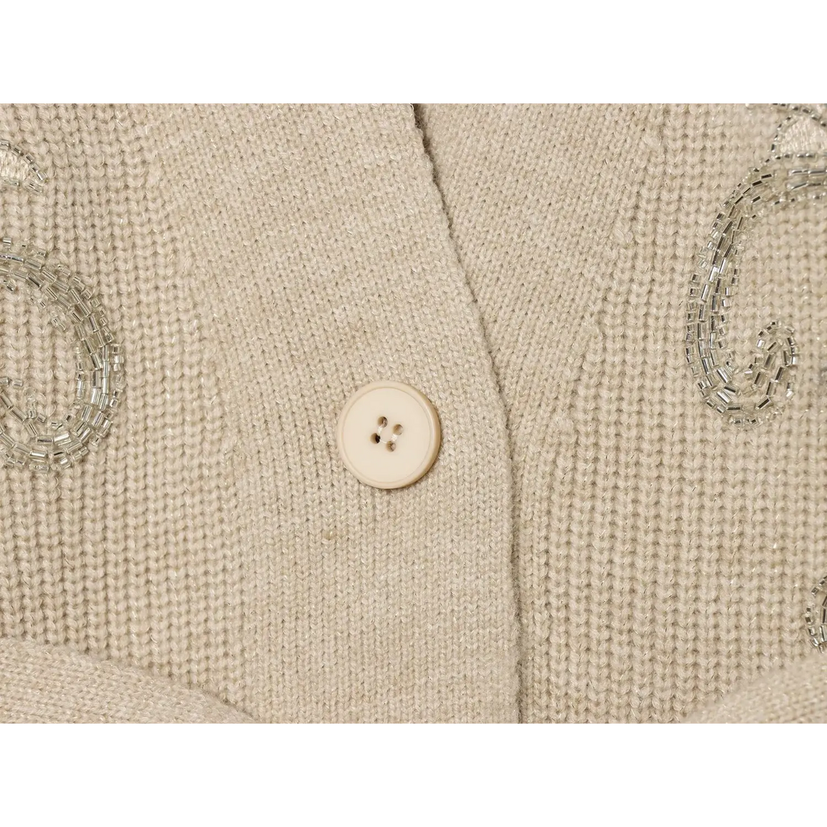 Close-up of beige four-hole button on V neck placket