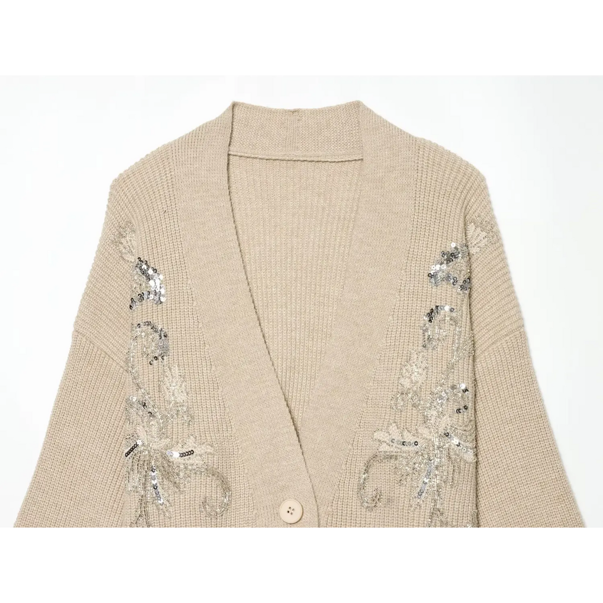 Close-up of beige V neckline and silver sequin beadwork floral embroidery on both shoulders