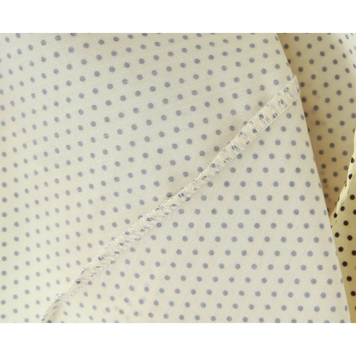Zigzag overlock seam close on yellow black dot cloth