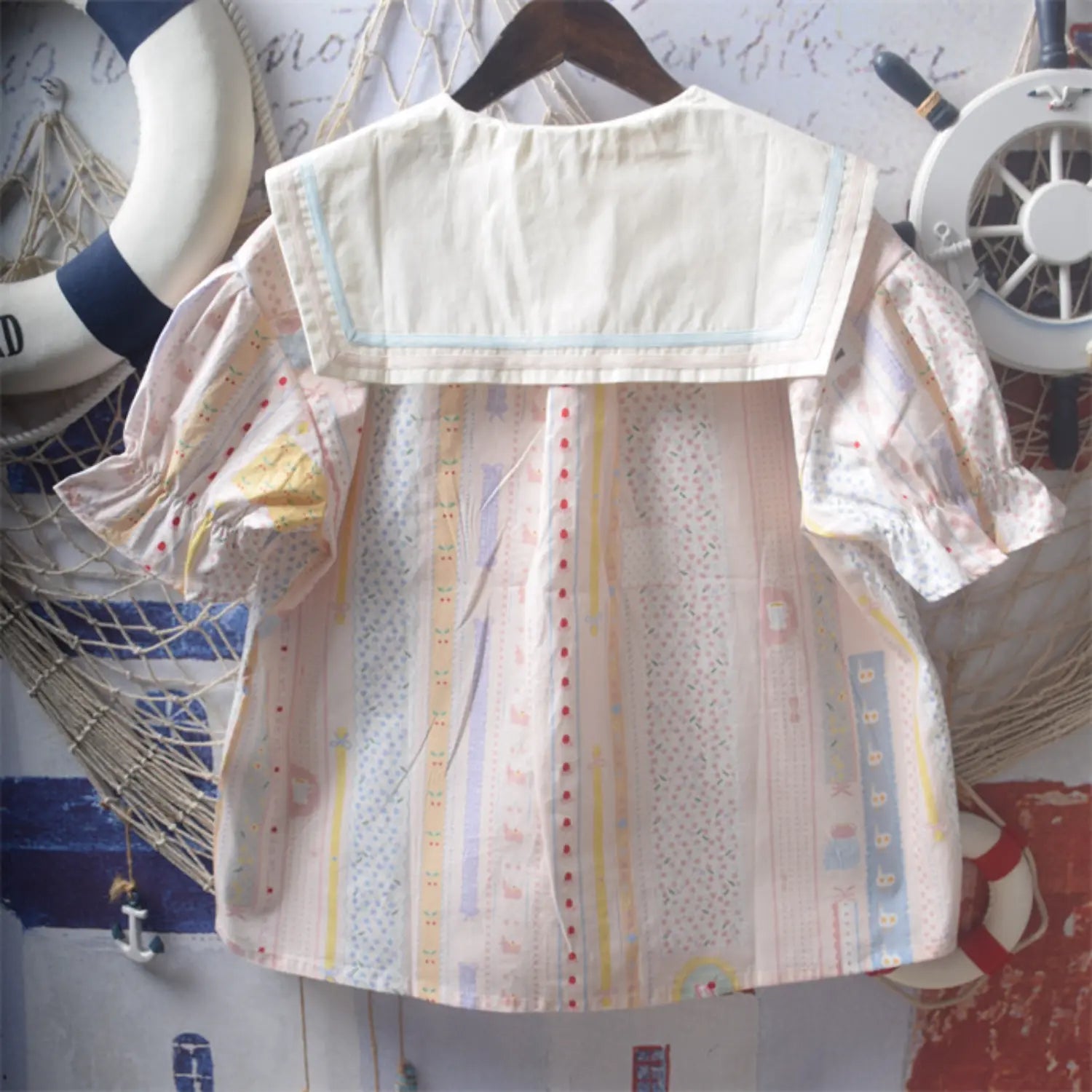 Short sleeve sailor collar printed blouse full back hanging shot, full cream sailor lapel back splicing full vertical cartoon print loose dropped shoulder puff sleeves back silhouette & print full display
