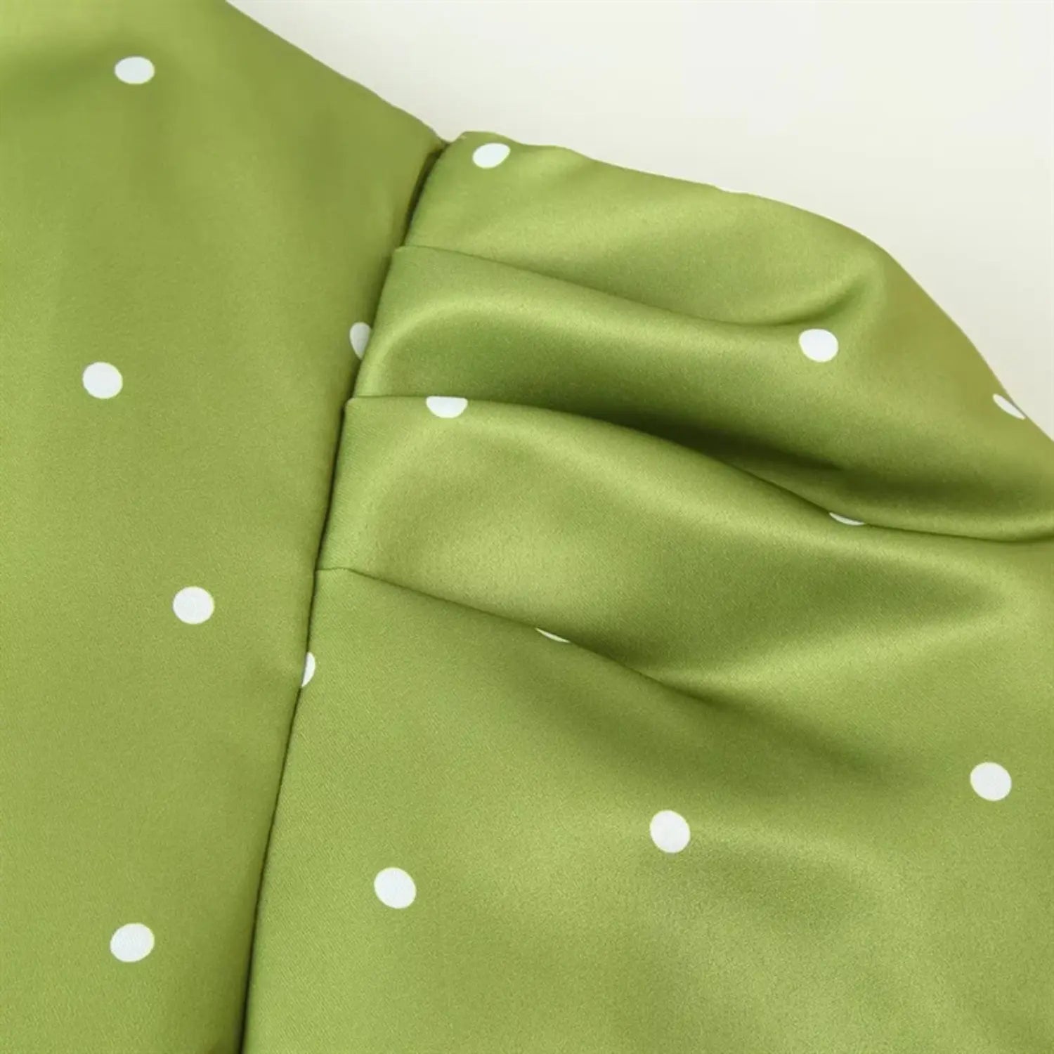 Extreme macro shot of shoulder joint, double layer gathering craft for puff sleeve, shoulder panel stitching, satin fabric luster display