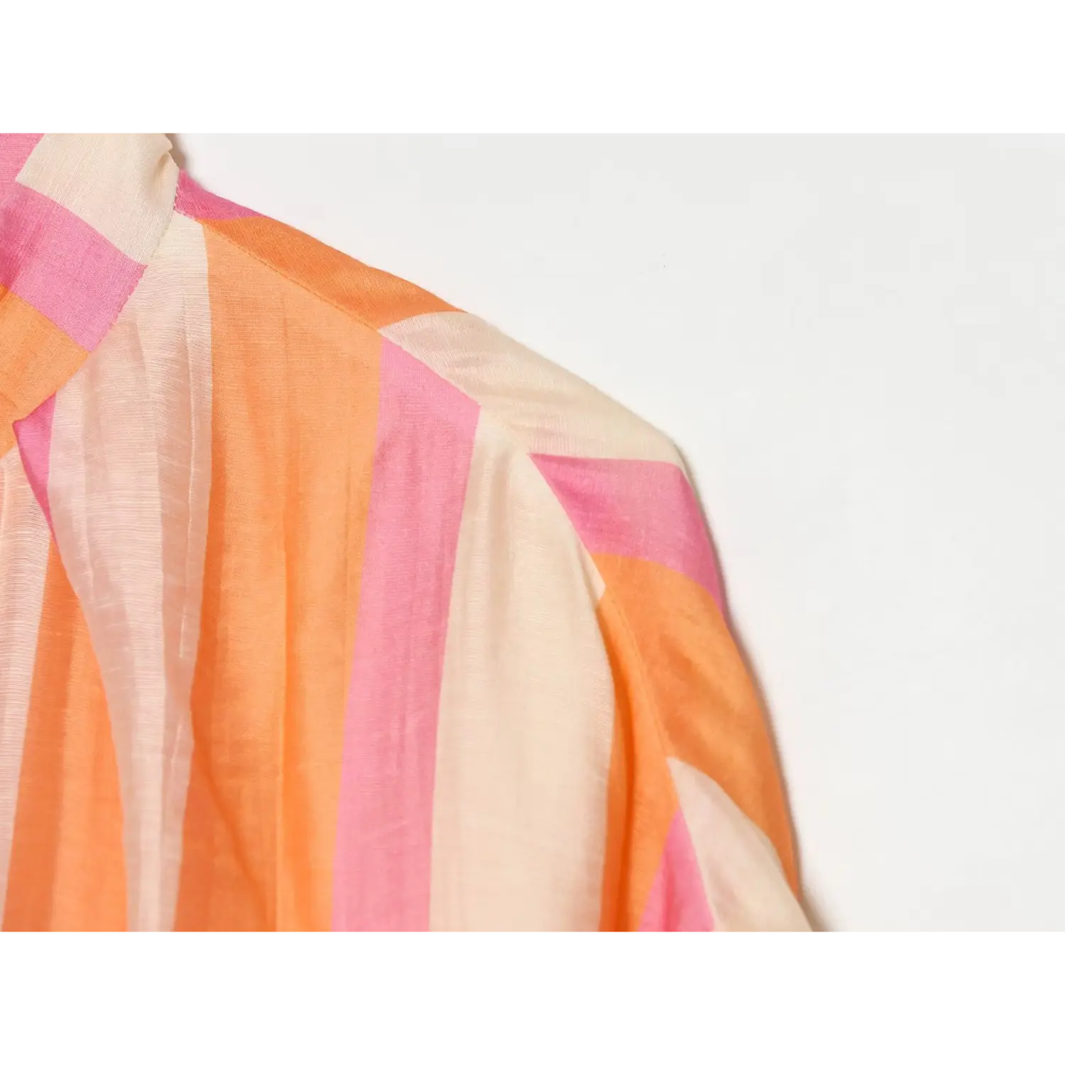 Shoulder and sleeve close-up, set-in sleeve seam, loose sleeve volume, continuous vertical stripe pattern