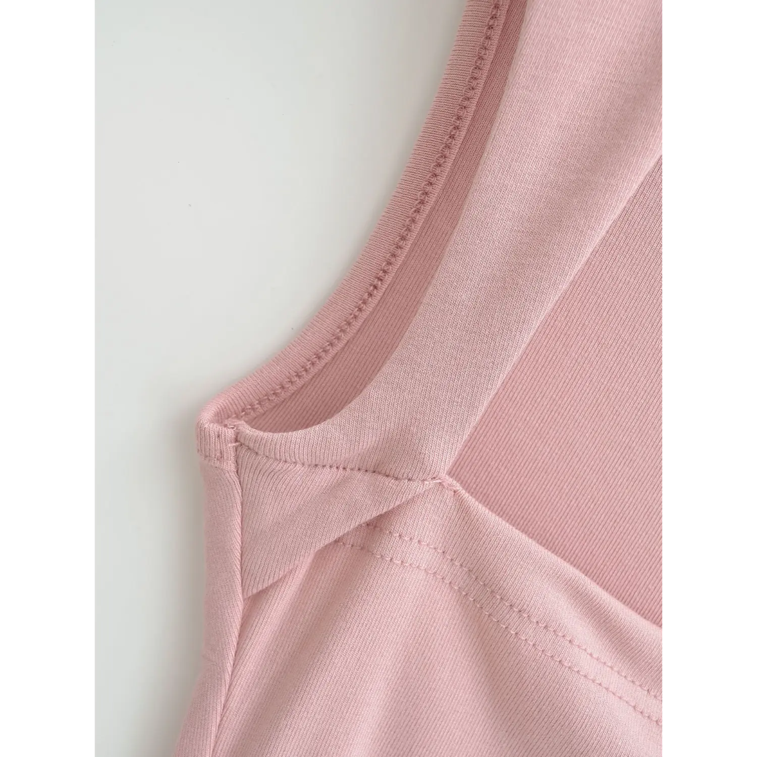 Close-up stitching detail at shoulder strap joint of dusty pink ribbed square neck cami top