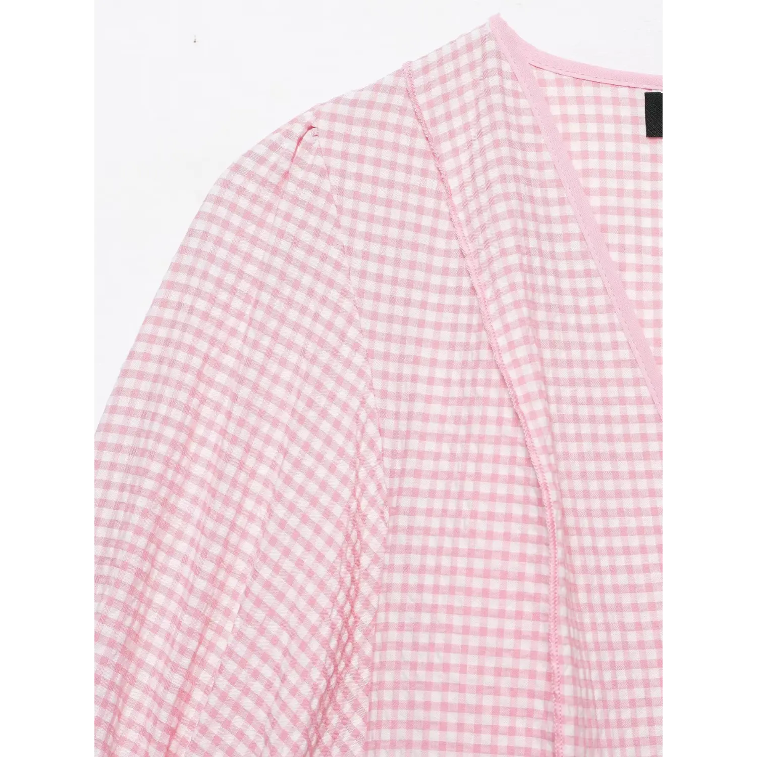 Shoulder and neckline partial close-up, v-neck piping trim, pink gingham crinkle fabric, shoulder gathering stitching