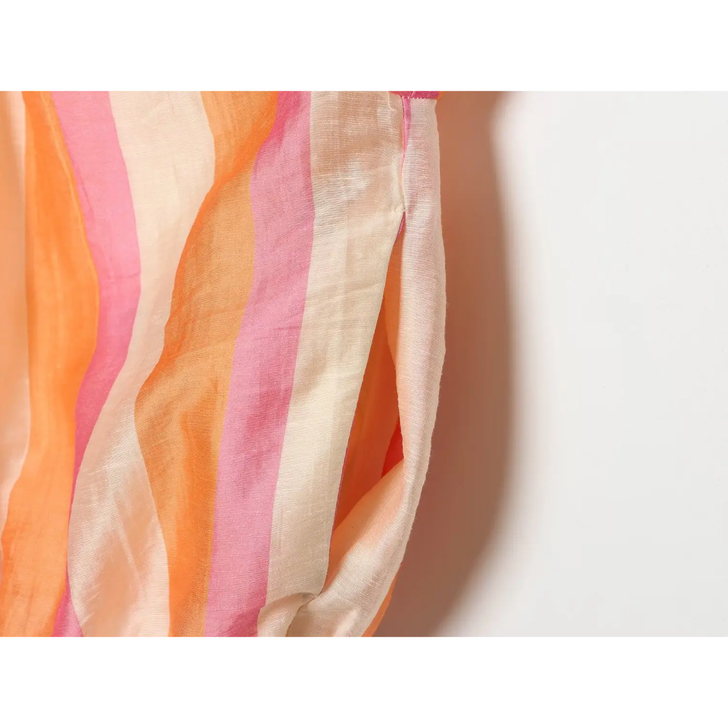 Side sleeve close-up, lightweight semi-sheer drape, crinkle woven texture, bright vertical stripe layout