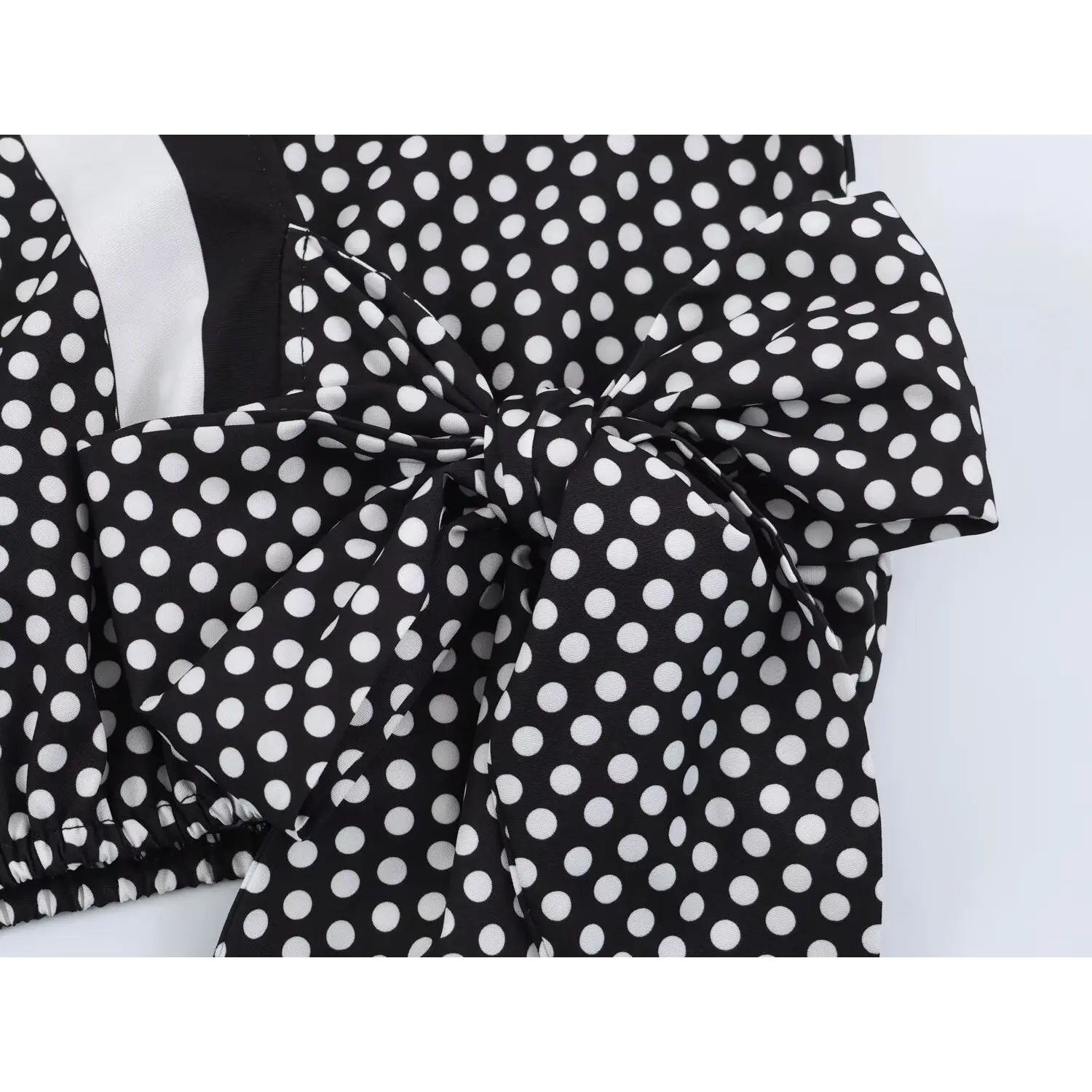 Side waist tie knot macro shot, thick polka dot woven material, fine finished stitching