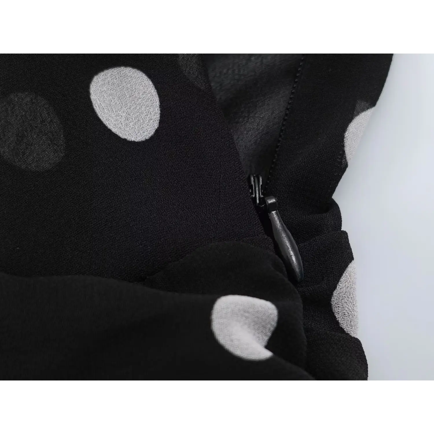 Side waist invisible zipper macro shot, matching polka dot fabric tape pull tab