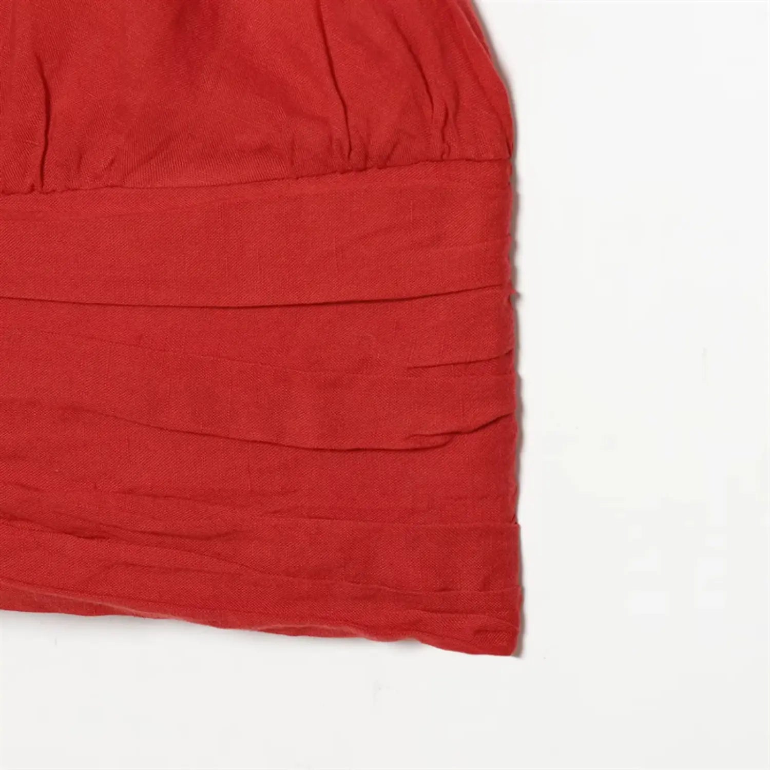 Side waist partial view, horizontal layered shirring, side seam stitching, soft lightweight red fabric drape