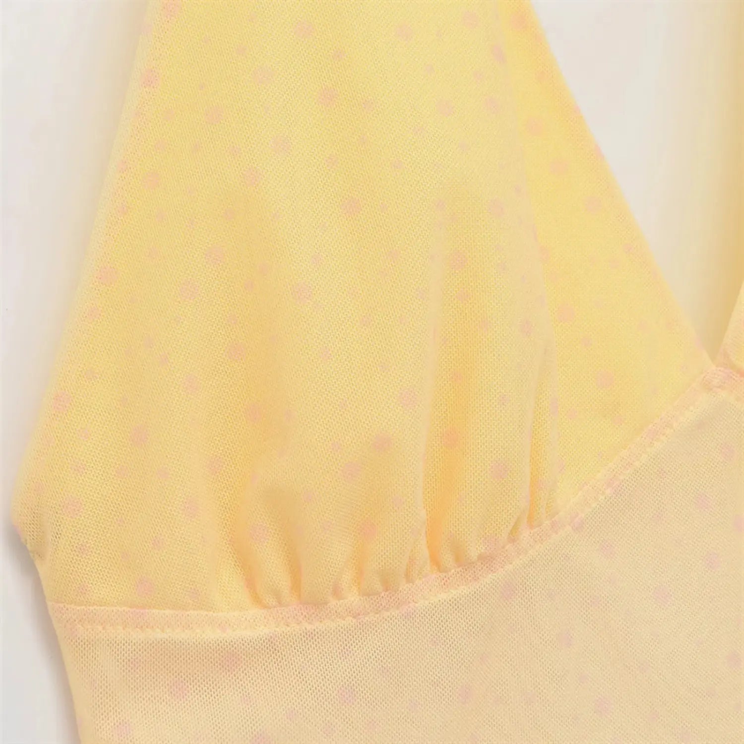 Side waist partial view, horizontal ruched seams, fitted waist shaping, sheer dot mesh overlay over solid yellow lining
