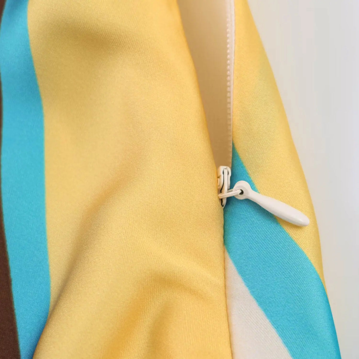 Close‑up of hidden side zipper on abstract print halter mini dress